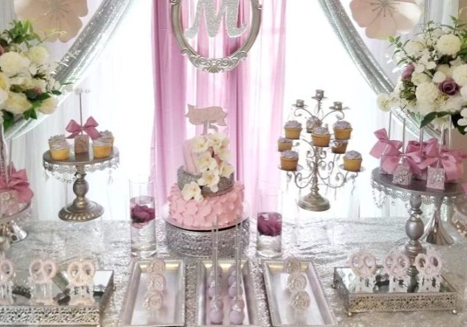 Elegant purple and silver-themed dessert table with cupcakes, floral arrangements, and a central birthday cake